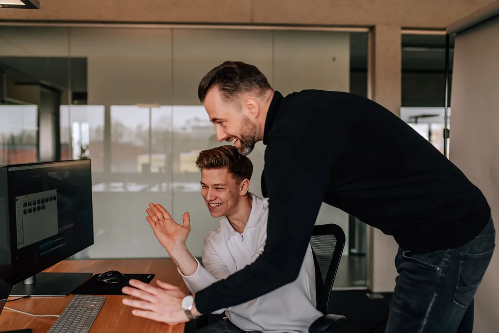 Zwei Mitarbeiter von HELLO AD! werten gemeinsam eine Kampagne am Bildschirm aus